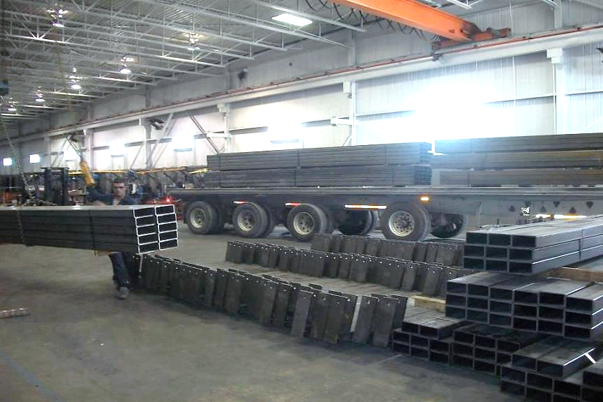 Shop floor, with a struck being loaded with machined beams.